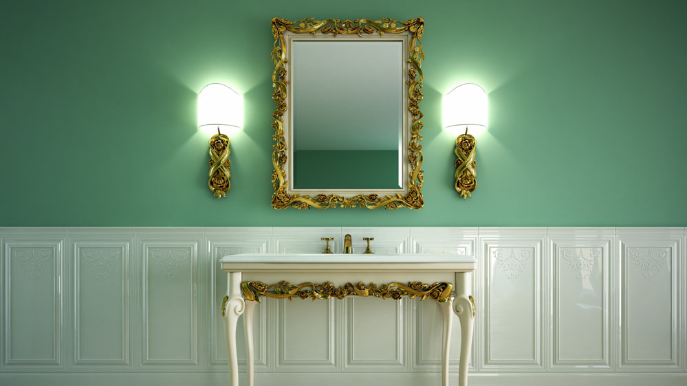 Χρυσές απλίκες μπάνιου σε πράσινο τοίχο ανάμεσα στις οποίες βρίσκεται ένας καθρέφτης με χρυσή περίμετρο.