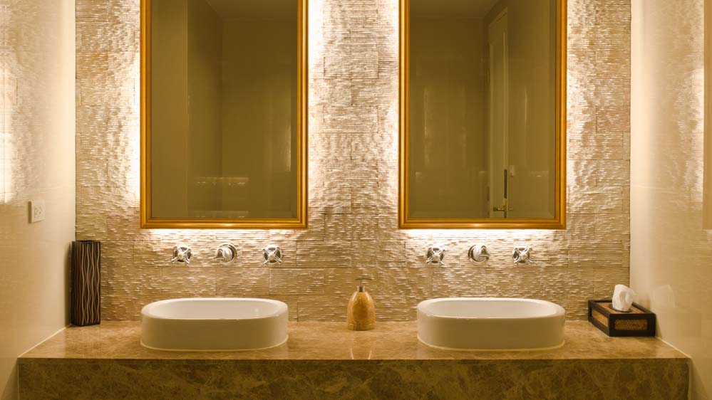 Κρυφός φωτισμός μπάνιου, με κρυμμένα σποτάκια τοποθετημένα πίσω από δύο ορθογώνιους καθρέφτες μπάνιου, που είναι δίπλα-δίπλα