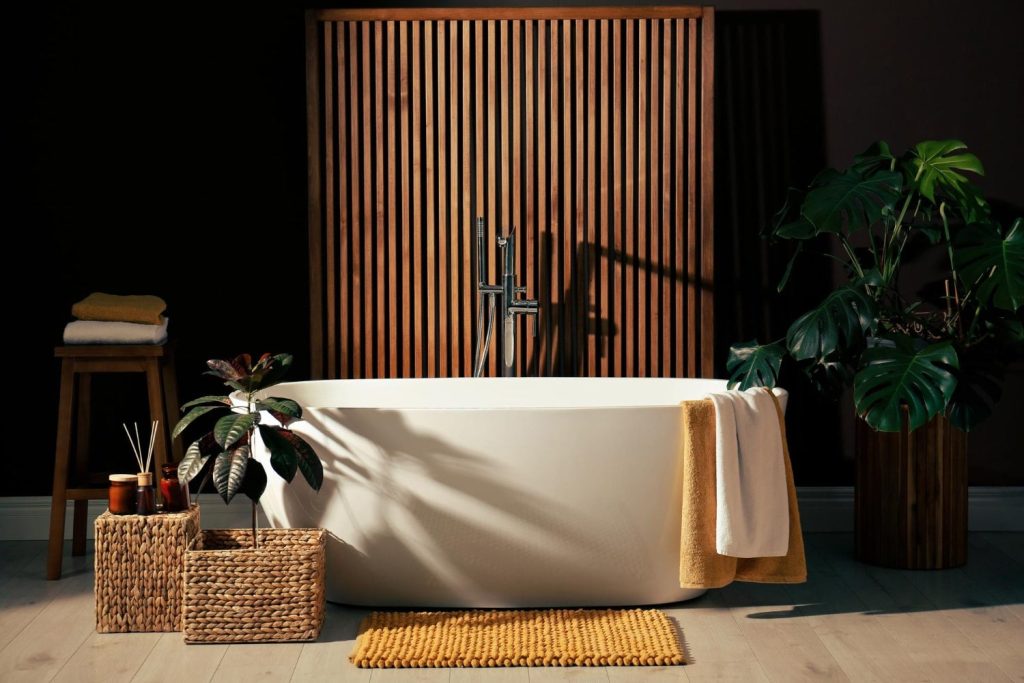 Μπανιέρα ελεύθερης τοποθέτησης σε μπάνιο με βιοφιλικό σχεδιασμό. Στον χώρο υπάρχουν φυτά και στοιχεία από υλικό bamboo.